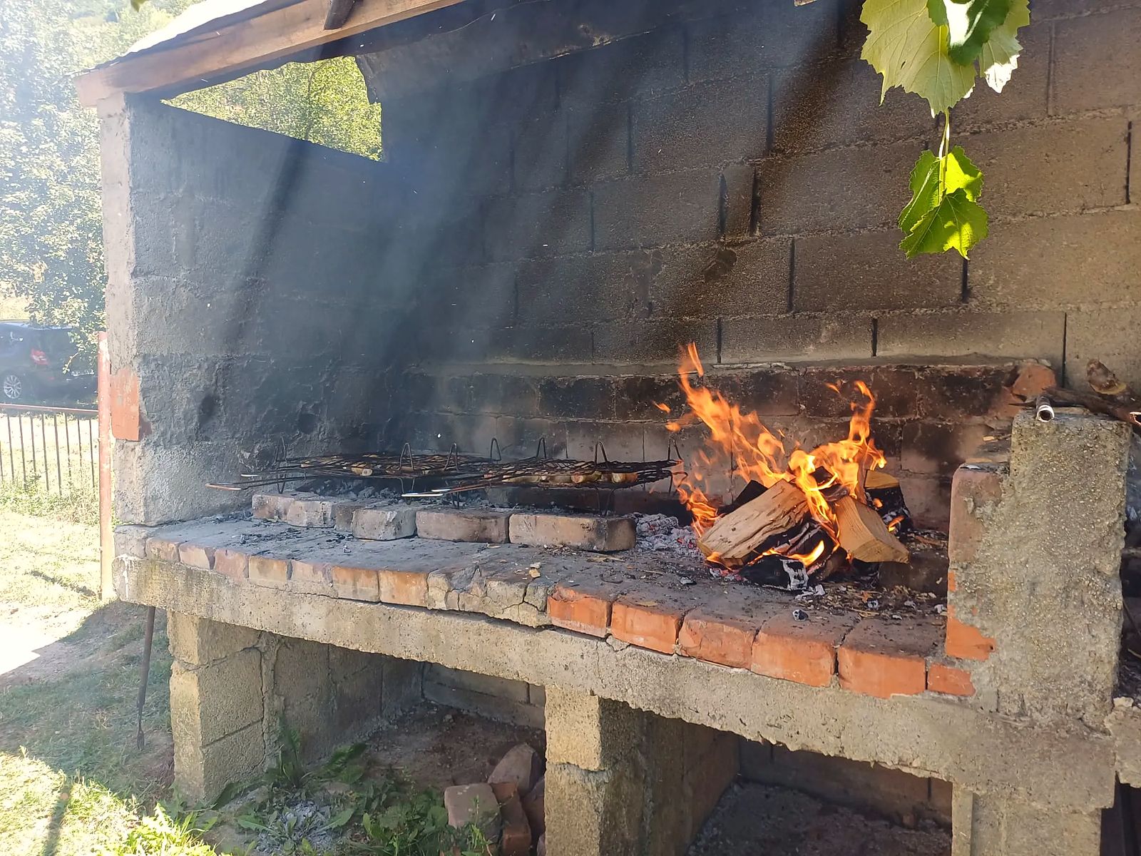 Gemauerte Feuerstelle mit Rosten über offener Flamme