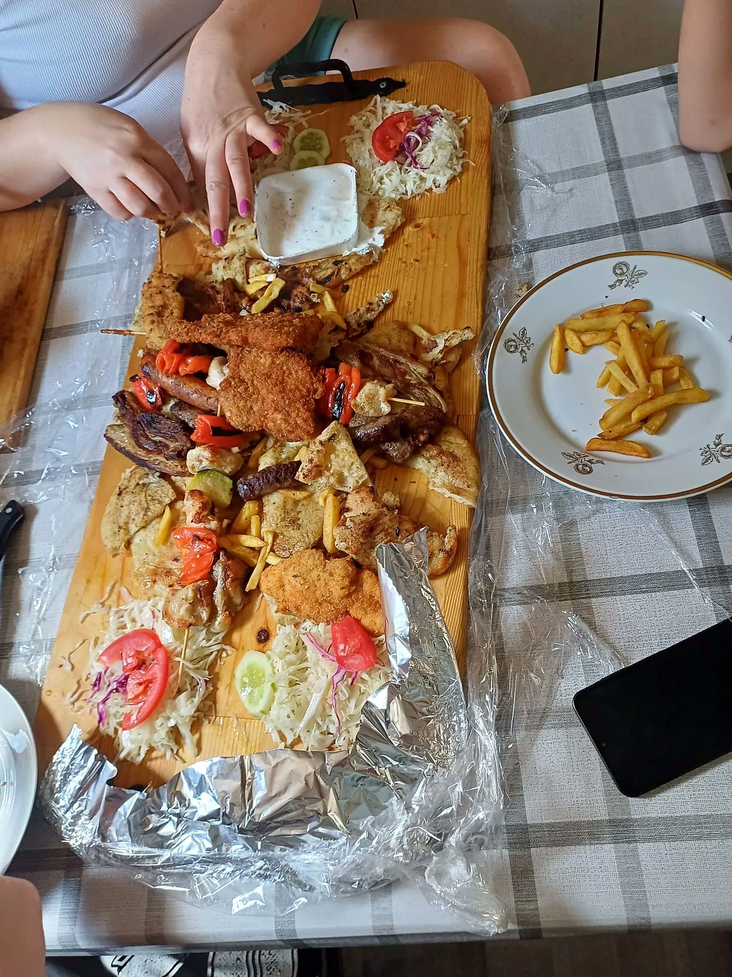 Volle Grillplatte mit Ćevapčići, Spießen und Beilagen